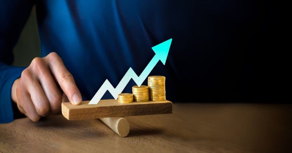 Person balancing coins with upward trend