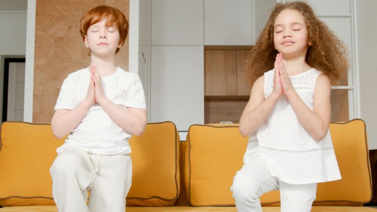 Two young children doing yoga exercises together, promoting a healthy and active lifestyle.